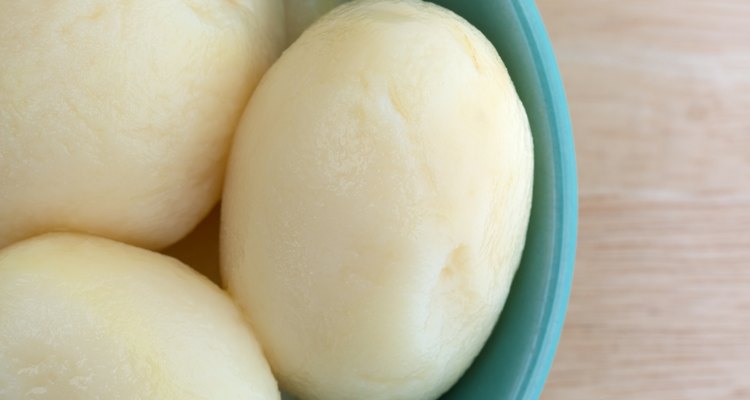 White potatoes in a bowl on a wood table top