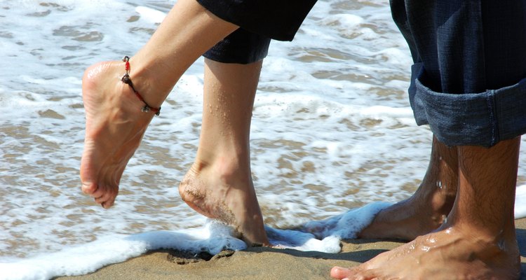 Close-up of a couple's feet on the beach