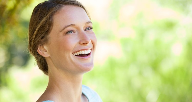 Cheerful thoughtful woman looking away in park