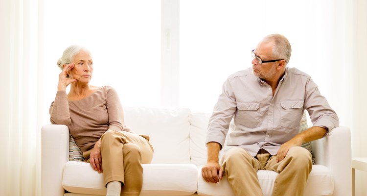 senior couple sitting on sofa at home