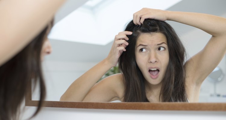 Horrified young woman looking in the mirror