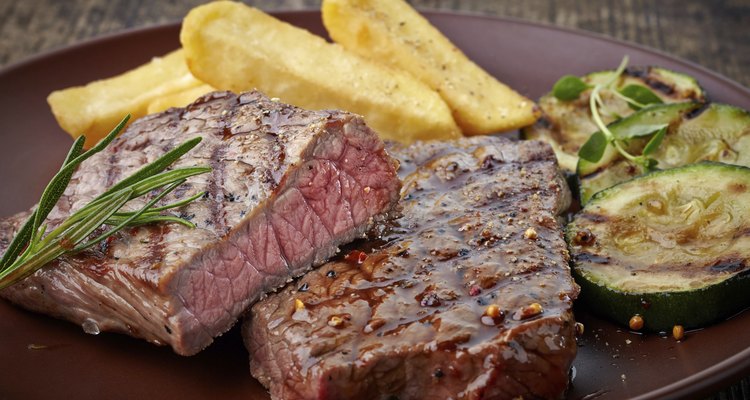 grilled beef steak on wooden cutting board