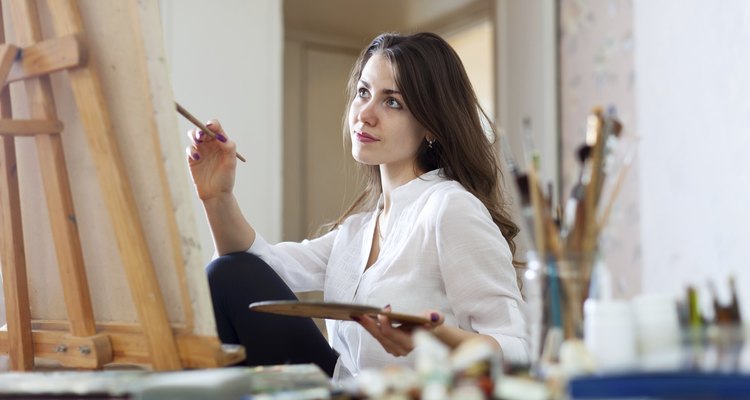 woman paints picture on canvas