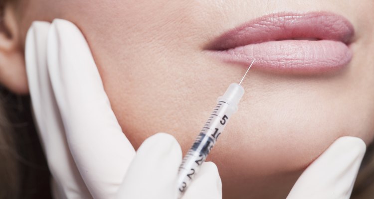 Close up of woman receiving botox injection in lips