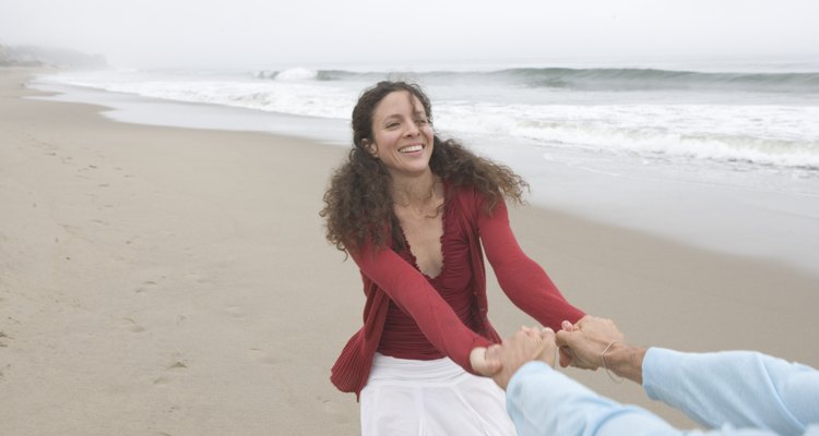 Woman pulling her boyfriend at the beach