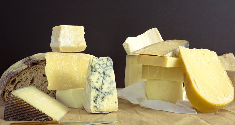 Cheeses and bread on block with knives