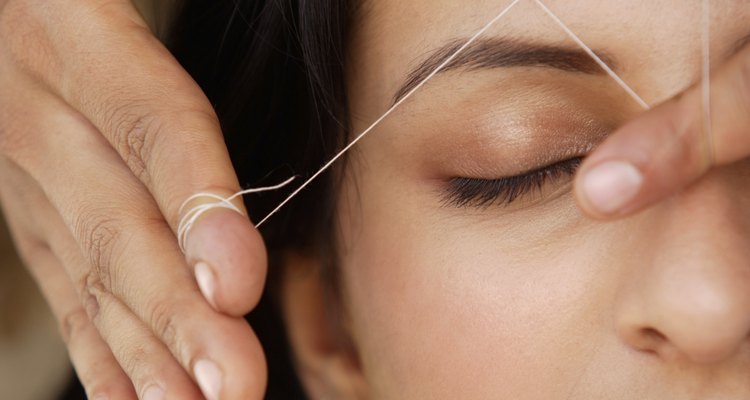 Woman getting eyebrow threading treatment