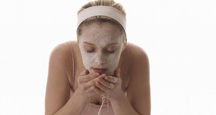 Woman washing face with facial mask