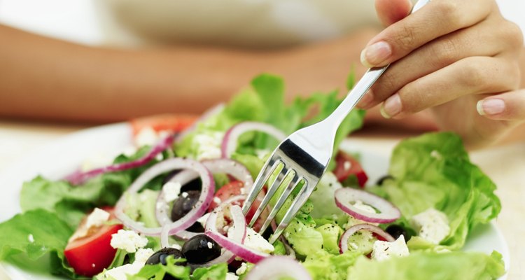 Close-up of a person eating salad with a fork