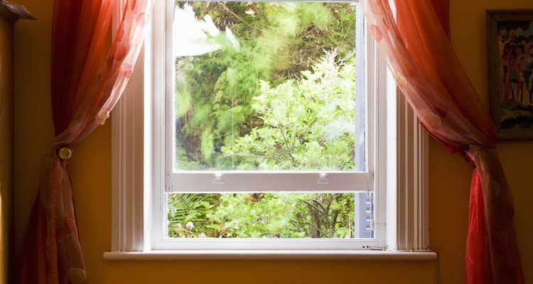 Long, sheer curtains tied back farther than normal emphasise the shape of the furniture.