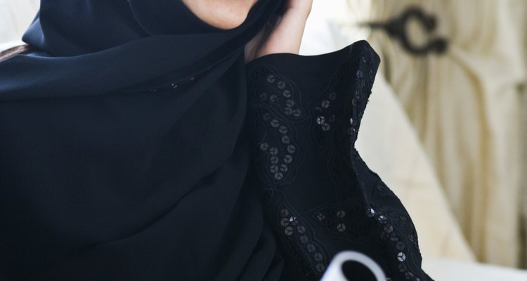 Finaliza la abaya por el recorte de los bordes y la adición de elementos de fijación a lo largo de la longitud.