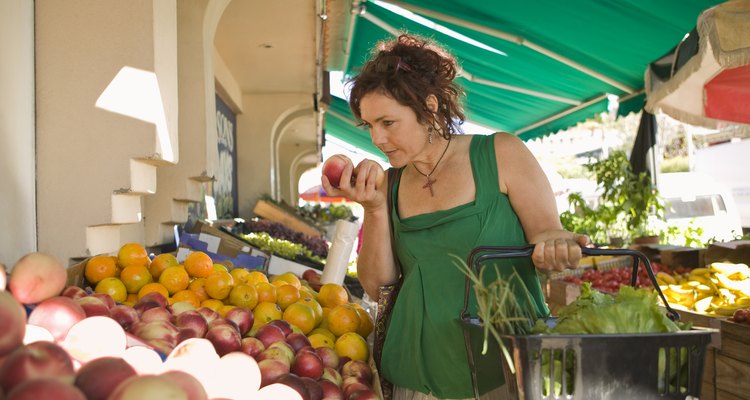 Woman smelling produce at outdoor market
