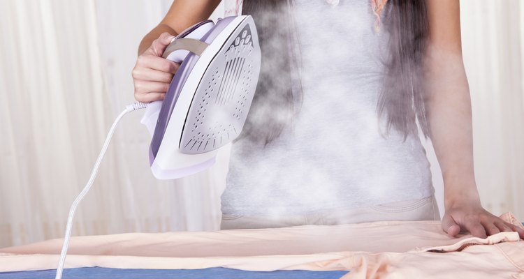 Cheerful housewife ironing the clothes