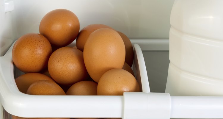 Fresh brown whole eggs and milk in refrigerator