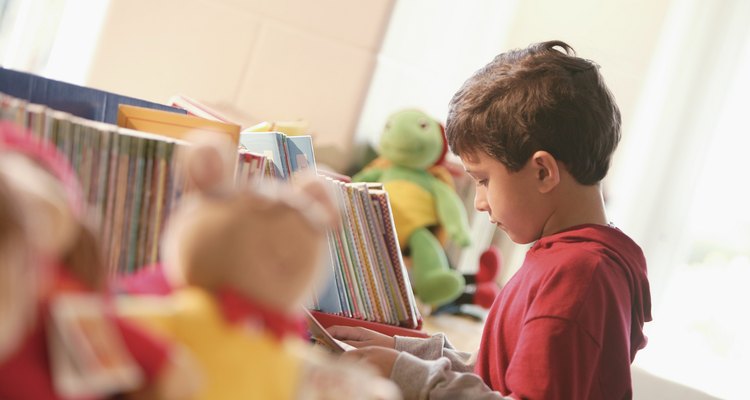 Un pequeño niño mirando un libro en la biblioteca.