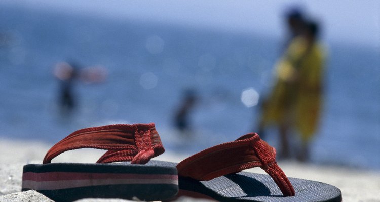 Photo, a close-up of thong sandals sitting on a beach, Color