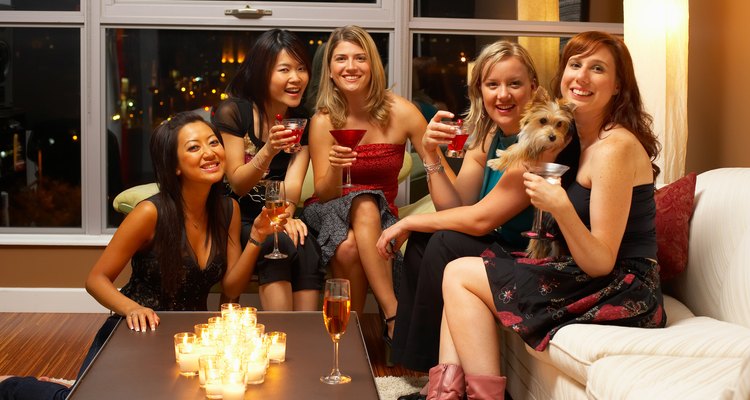 Women posing with pet dog at party in condominium