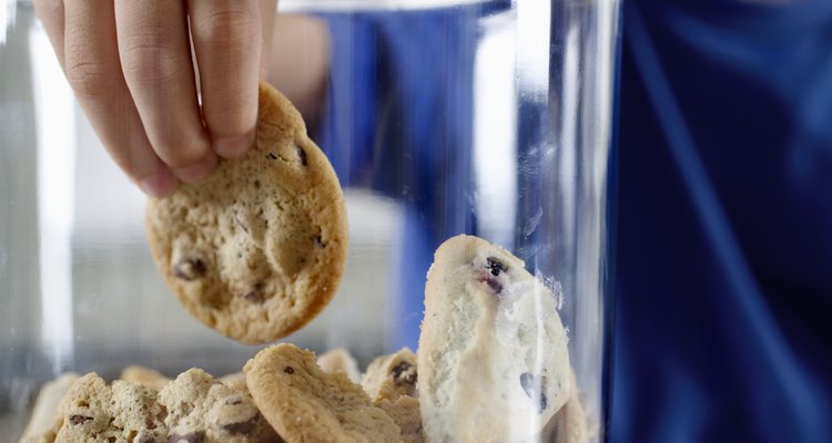 Boy (6-8) reaching into cookie jar