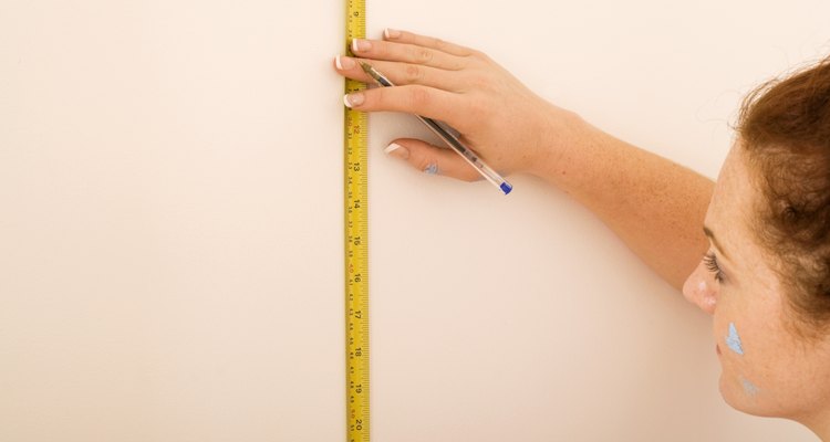 Woman measuring wall