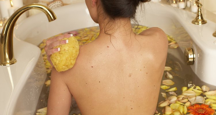 Woman having flower bath, rear view