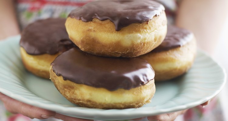 Woman holding plate of Boston creme doughnuts