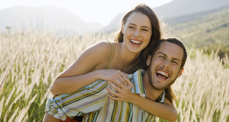 Man giving woman piggyback ride in field