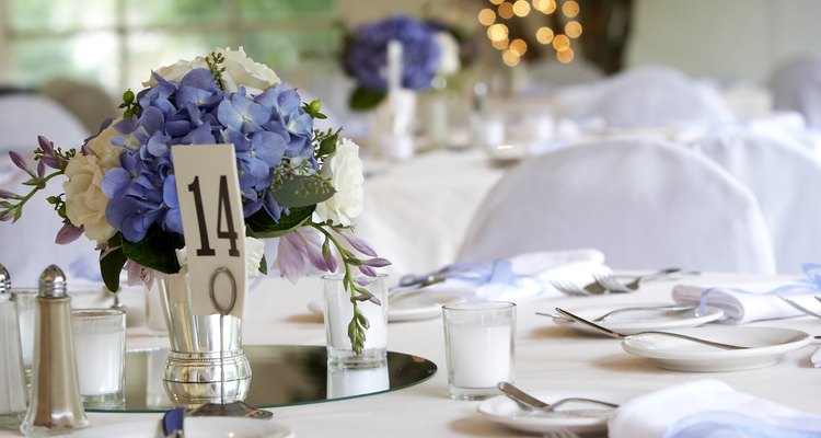 Las flores en azul son la decoración central de una mesa durante la recepción.