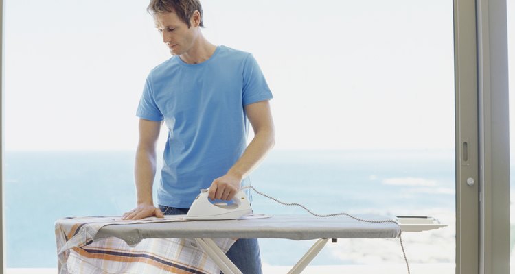 Hombre planchando una camisa.