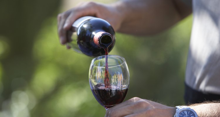 Man pouring wine, close-up of glass