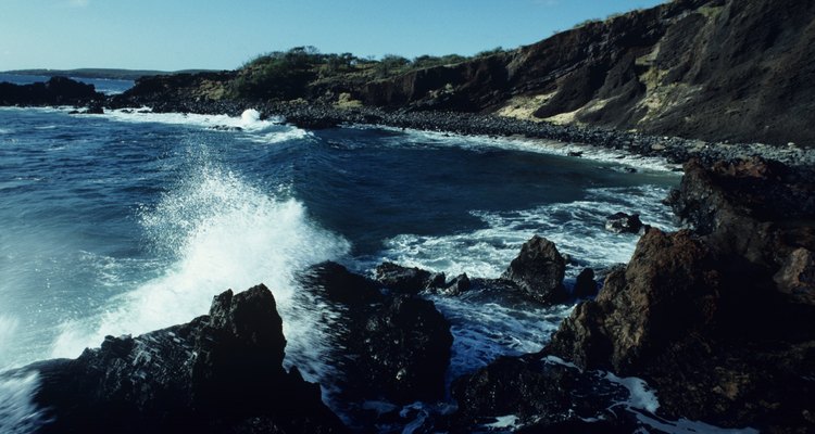 Wave crashing on rocky shoreline, Hawaii, USA