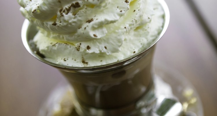 Coffee cup with whipped cream topping on table, elevated view