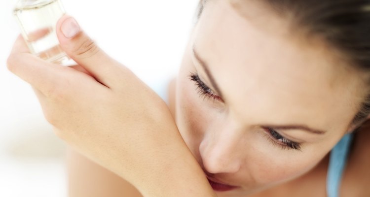 portrait of a young woman smelling perfume on her wrist