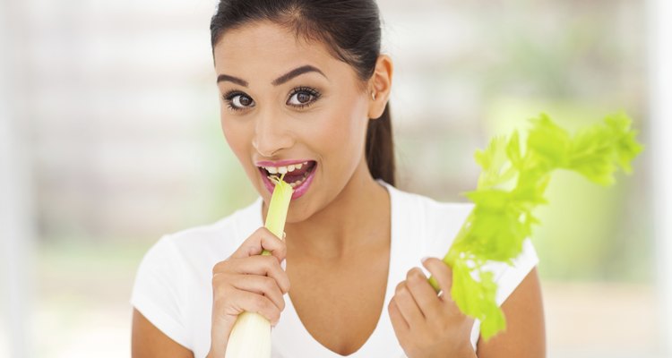 young woman biting fresh celery stick