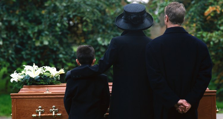 portrait of a young couple and their son standing in a cemetery