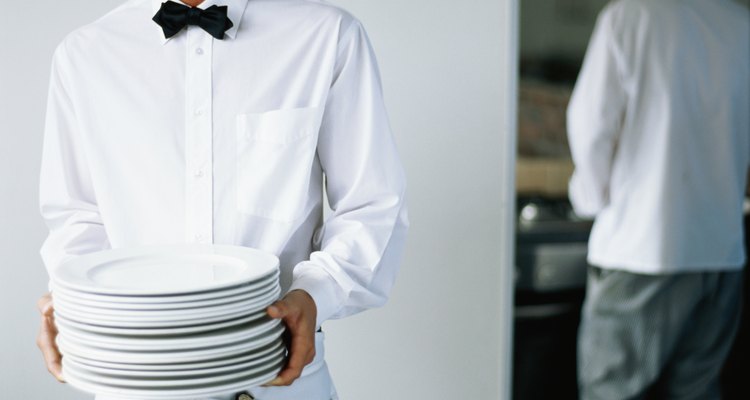 Restaurantes frequentemente exigem que os garçons cubram tatuagens nas mãos e removam seus piercings
