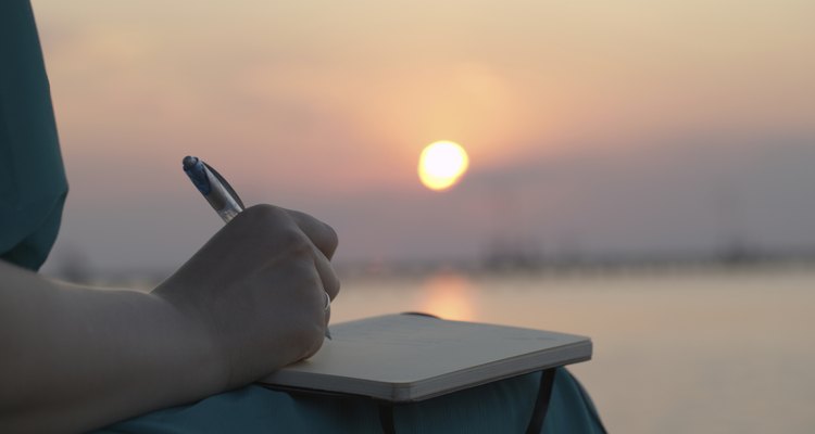 Woman writing in her diary at sunset