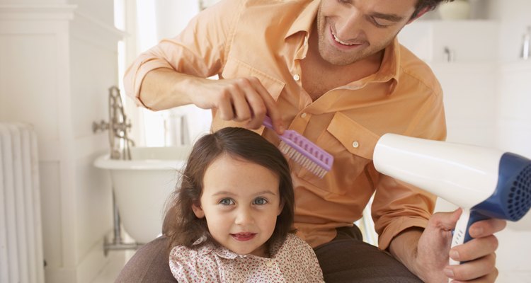 Father blowdrying daughter's (2-4) hair, close-up