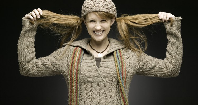 Woman in woollen outfit pulling her hair sideways, portrait