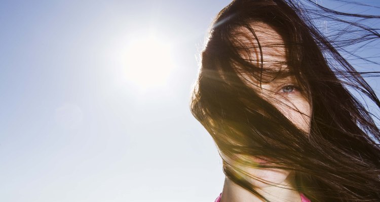 Woman with messy hair blowing on windy day