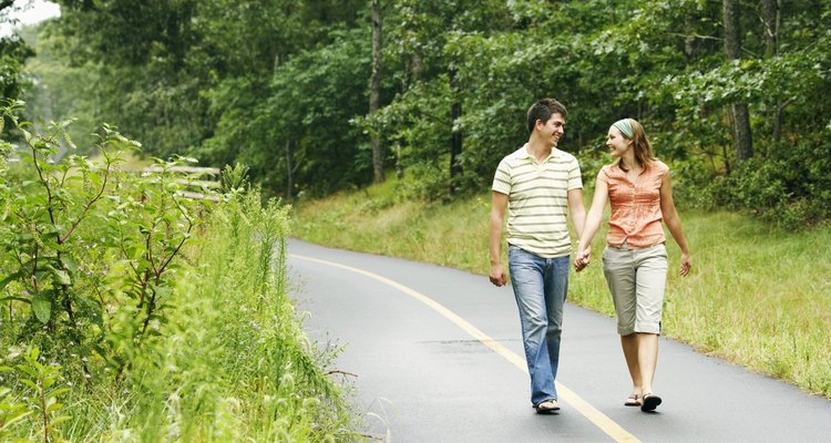 Couple holding hands while walking along path