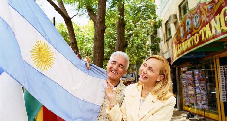 Pareja sosteniendo la bandera de Argentina.