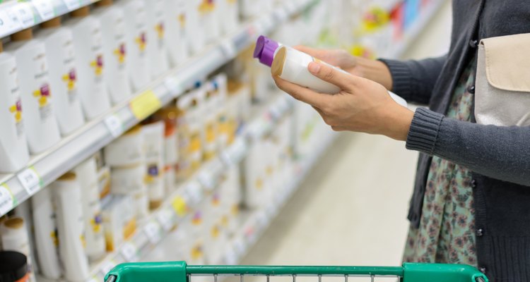 women comparing shampoo  in supermarket