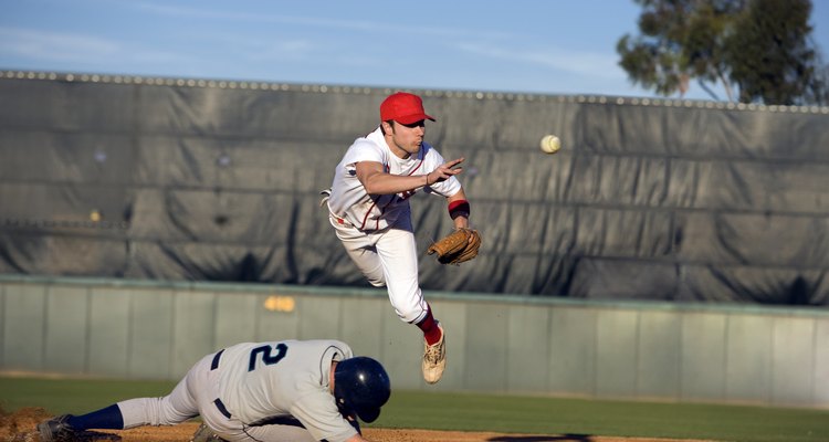 USA, California, San Bernardino, baseball runner sliding for base and baseman leaping for catch