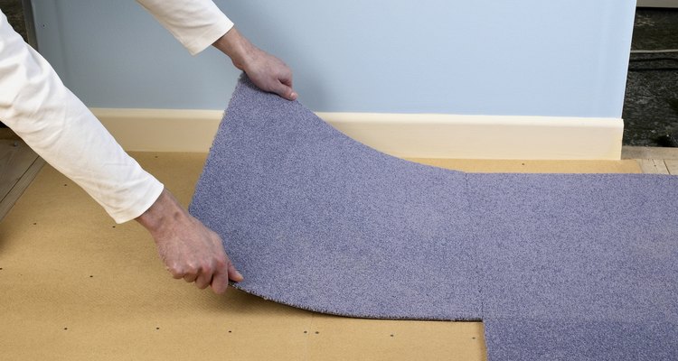 Hombre instalando una alfombra.