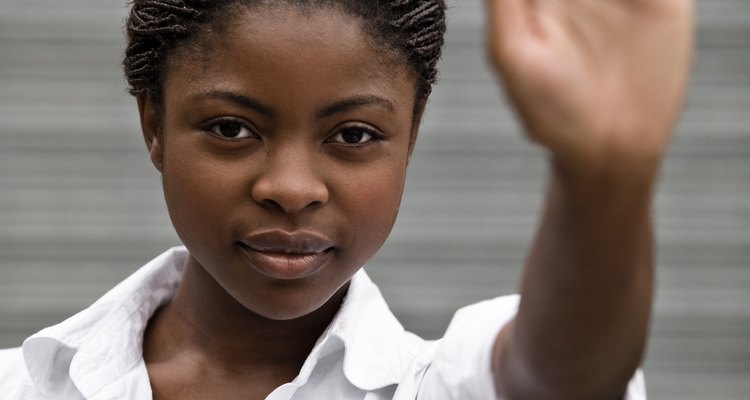 This woman is using nonverbal communication to tell others to stop.