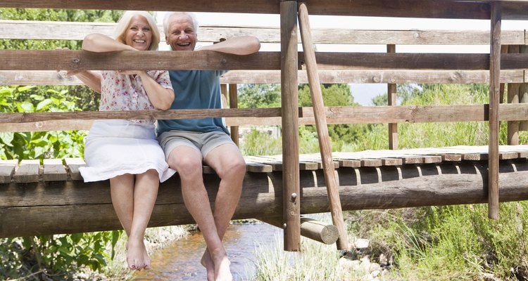 Couple sitting on rural bridge