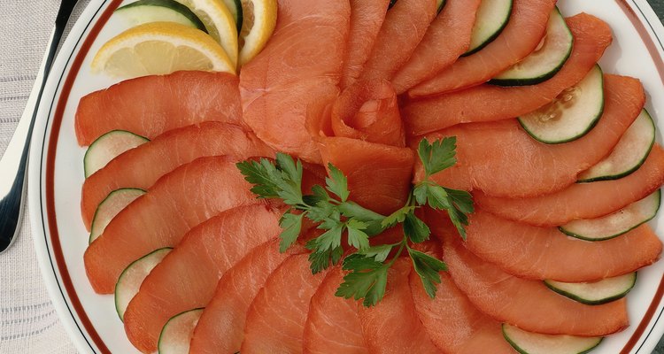 El salmón ahumado sabe delicioso solo con un poco de limón y rodajas de pepinos.