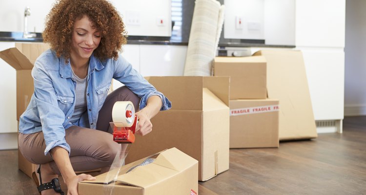 Woman Sealing Boxes Ready For House Move