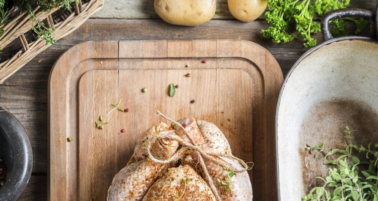 Preparing roast chicken with herbs and vegetables