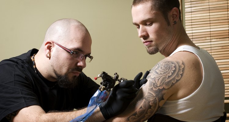 Tattooer concentrating on giving someone a tattoo